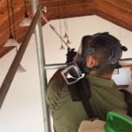 Técnico con respirador en un altillo de madera