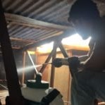 Técnico aplicando tratamiento bajo techo de zinc